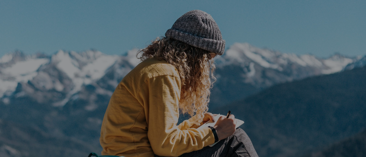 mujer escribiendo en el medio de un bonito paisaje